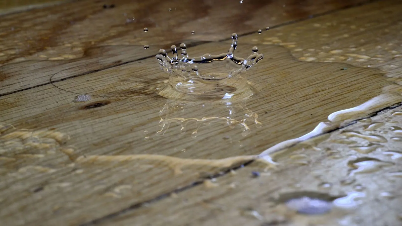Water pooling on weathered wood floor planks